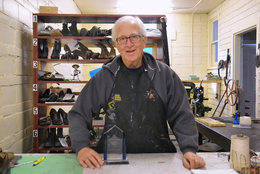Currie’s Shoe Repair owner David Currie stands in his shop on Kent Street, posing with an award he recently received. Currie has been working at the family’s 116-year-old business for six decades.