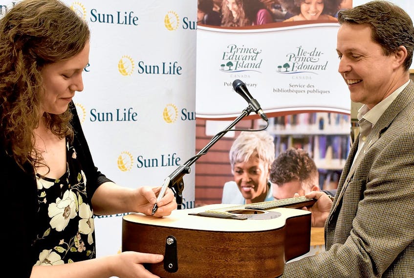 Catherine MacLellan donated one of her guitars to the Summerside Rotary Library Thursday morning. MacLellan performed as part of a presentation dozens of musical instruments and $140,000 to maintain them and from Sun Life. The instruments are now part of the provincial collection and anyone with a library card can borrow one. The library is also accepting instrument donations from the public, like the guitar from MacLellan. The money from Sun Life will allow the library to get donated items checked over and made ready for lending. MacLellan (pictured) signed her guitar for Education Minister Brad Trivers at the Summerside Rotary Library June 6.