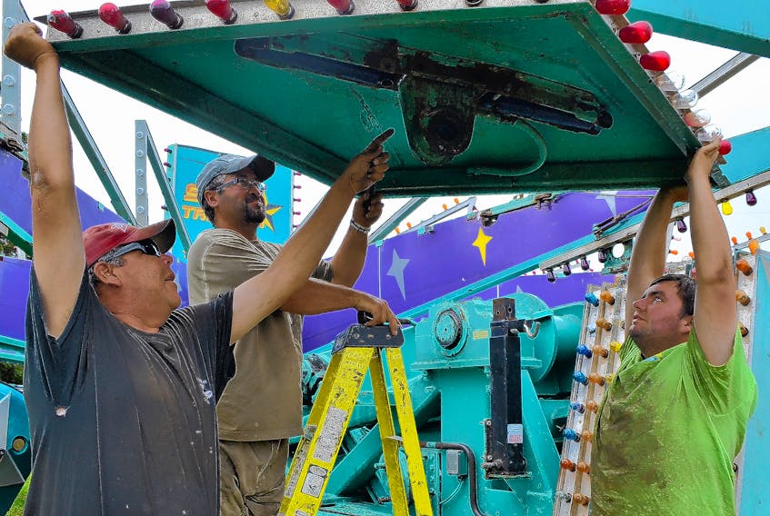 Hinchey’s Rides and Amusements workers, from left, Shawn Turgeon, Donald Francis and Daniel McLaren team up to assemble the midway’s Star Trooper ride. The midway is getting the rides set up in Alberton early in preparation for the July 26-28 Prince County Exhibition.