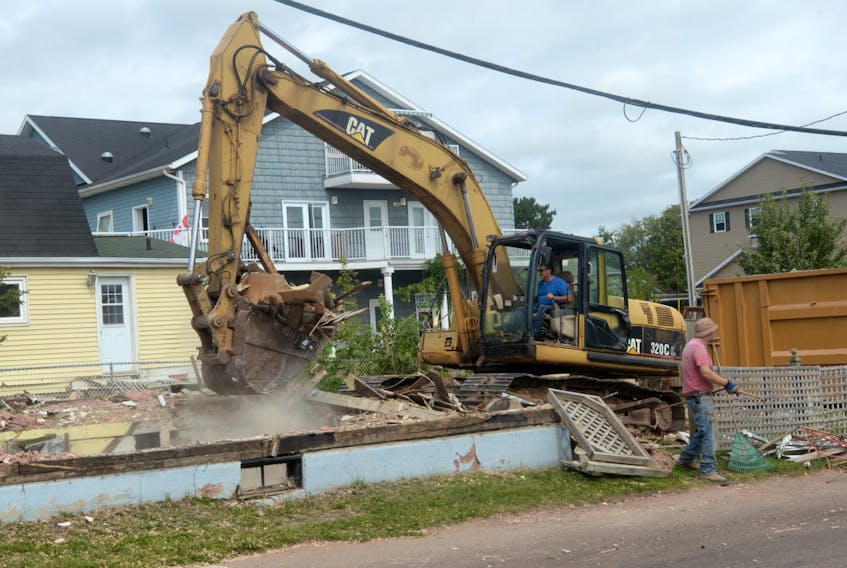 Workers clean up some debris from the demolition of a home at the corner of Queen and Pond Streets, which was purchased by the City of Charlottetown earlier this year.