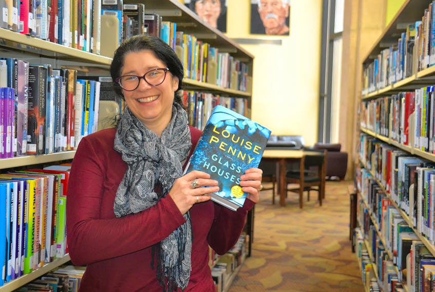 Beth Clinton, regional librarian at the Confederation Centre Public Library, holds up “Glass Houses” by Canadian author Louise Penny, which made the Top 10 list of most borrowed print titles across P.E.I. in 2018.