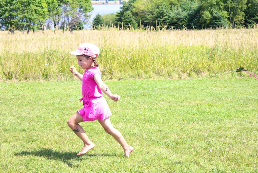 Kianna Scott, 5, flies a tiny kite during the Acadian family fun day at Skmaqn-Port-la-Joye-Fort Amherst. Parks Canada added the name Skmaqn to the site in February, and the Acadians settlers’ relationship with the Mi’kmaq was highlighted throughout the day.