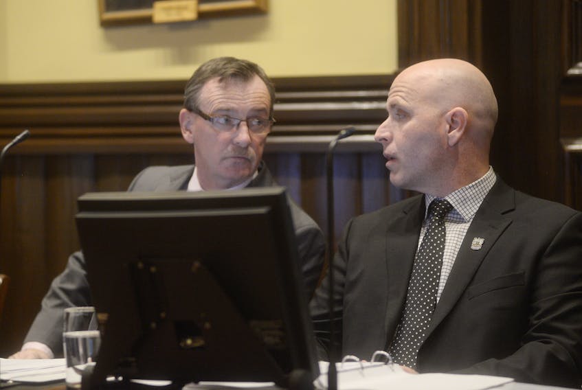 Charlottetown Coun. Terry MacLeod, left, and Coun. Greg Rivard talk prior to Tuesday’s council meeting. The meeting saw council pass the first two readings of a resolution to permit construction of a 23-unit apartment building on Richmond Street.