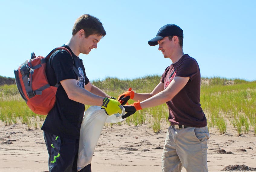 UPEI students Cale Pierce, left, and Mathieu Meyer collect garbage along the shoreline of Cavendish Campground. Some of the garbage collected during the Great Canadian Shoreline Cleanup in P.E.I. included fish nets, buoys and wrappers.
