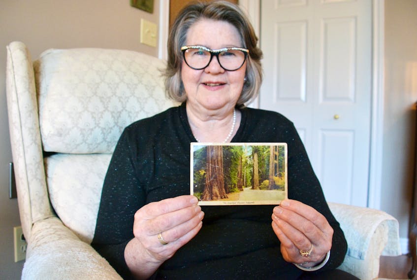 Carol Maclauchlan sits in her Charlottetown home while admiring a postcard she sent to her parents 49 years ago that was recently returned to her.