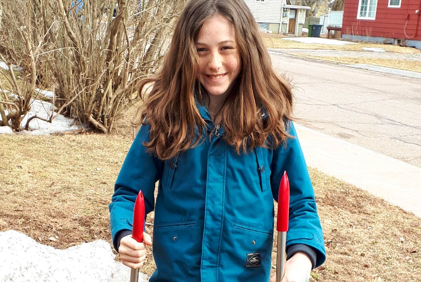 Iyla Kilbride practises scooping poop in her front yard in Summerside. The 10-year-old is turning the common chore into a summer job.