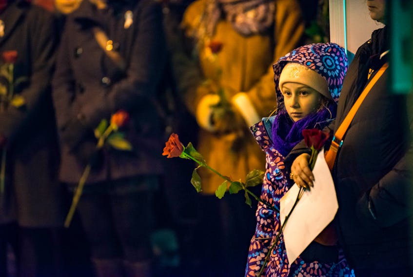 A young girl attends a vigil in Montreal on Dec. 6, 2016, to remember the 14 female engineering students killed at l'École Polytechnique in 1989.