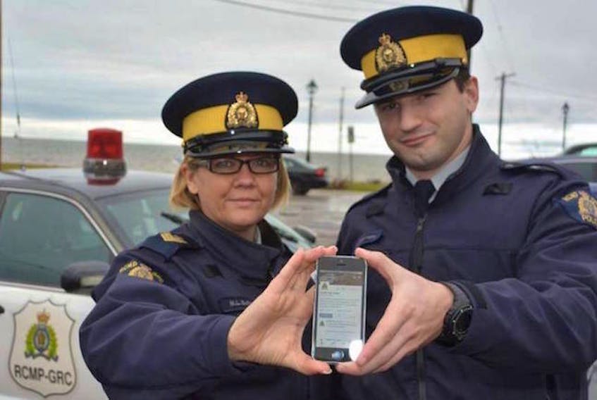Sgt. Leanne Butler and East Prince RCMP Const. Gabe Letourneau show off one of the Twitter pages that Island RCMP use to keep Islanders informed.
(Journal-Pioneer File Photo)