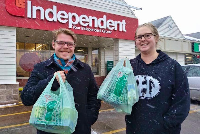 Tristan LeClair of Stratford and Jordon Havenga of Cornwall do some last-minute grocery shopping before the winter storm Thursday. LeClair and Havenga picked up some storm chips, milk and cookies and planned to spend the day cuddled up watching Netflix. 
(The Guardian / Maureen Coulter)