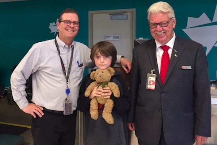 It was a happy reunion at the cargo area of the Charlottetown airport for nine-year-old Henry and his teddy bear Sutton. Assisting with the happy occasion are Air Canada employees Mark MacDonald, left, and Merrill Bell.

(Submitted photo)