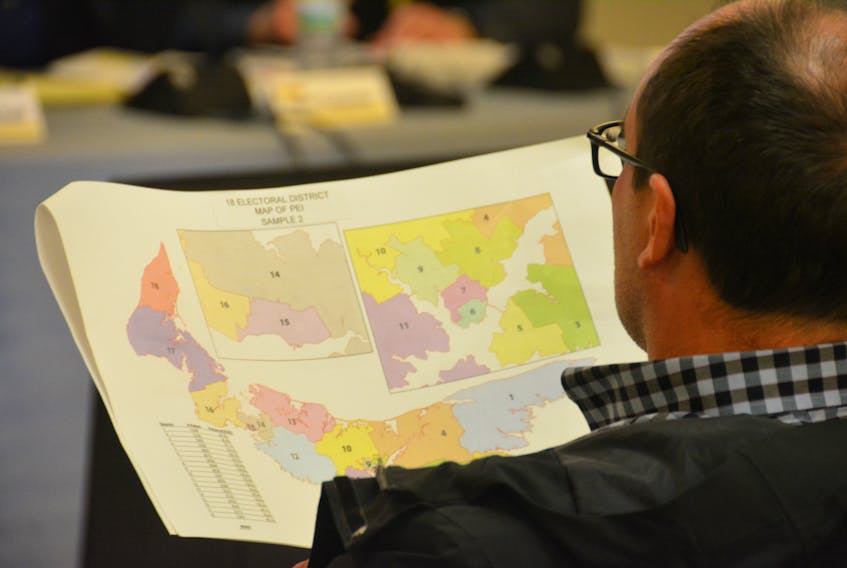 A person attending a public consultation in Summerside looks at the proposed 18-district map in this file photo.