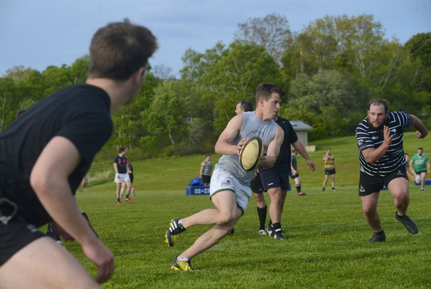 P.E.I. Mudmen Sheldon Cudmore, left, gets set to make a pass to teammate Phil Lanthier Thursday at Co-op Field.