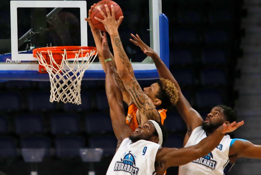 Island Storm’s Marcus Bell dunks on an alley oop, despite the defensive efforts by Halifax Hurricanes Rhamel Brown and CJ Washington during first quarter National Basketball League of Canada action in Halifax on Sunday. Tim Krochak/Halifax Chronicle Herald photo