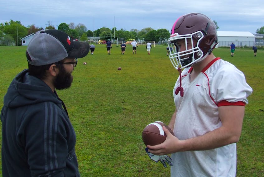 Island Mariners head coach Ryan Dempsey, left, and running back Richard Lush talk strategy at a recent practice. The Mariners face the Moncton Mustangs in one of two Maritime Football League semifinals on Saturday.