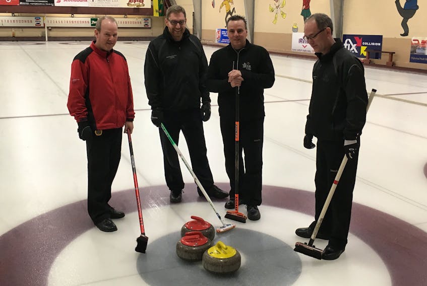 Team P.E.I., from left, fifth Robbie Younker, skip Eddie MacKenzie, coach Phil Gorveatt and lead Sean Ledgerwood of the P.E.I. Tankard-winning rink discuss a bit of strategy before a recent game in Charlottetown. The rink, which also includes second Chris Gallant and third Josh Barry, begins play at the Tim Hortons Brier today in Regina, Sask.