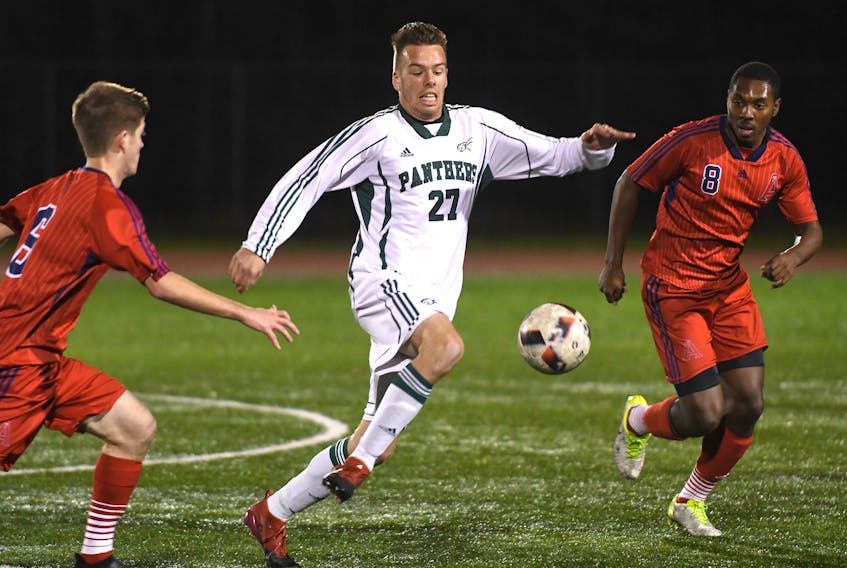 Lucas Ross of UPEI breaks between Sean Langille, left, and Ryan Parris of Acadia Axemen in quarter-final action of the Atlantic University Sport men's soccer playoffs on the campus of CBU Thursday night.