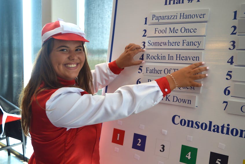 Gold Cup and Saucer ambassador Haley Thomson, the daughter of Arron and Michelle Thomson of Charlottetown, places the card of Rockin In Heaven on the board to set the order of Trial 1 Tuesday in Charlottetown. Rockin In Heaven is owned by Douglas E. Polley of Amherst, N.S., and Gordon E. McComb of Fall River, N.S.
