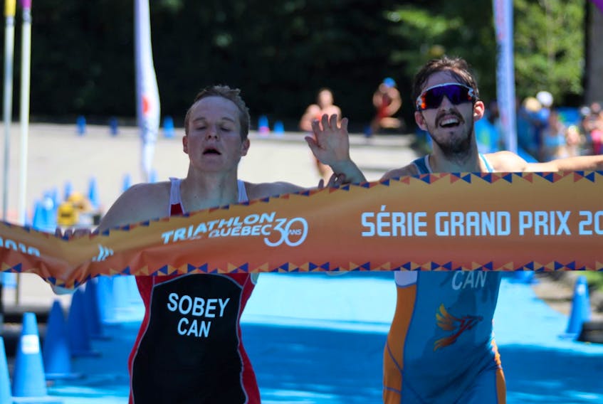 Charlottetown native Martin Sobey, left, crosses the finish line in the Grand Prix final A at the recent Gatineau triathlon last moth in Gatineau, Que. Sobey won the elite division over Quebec’s Edouard Garneau, right, to take the gold medal by two-tenths of a second.