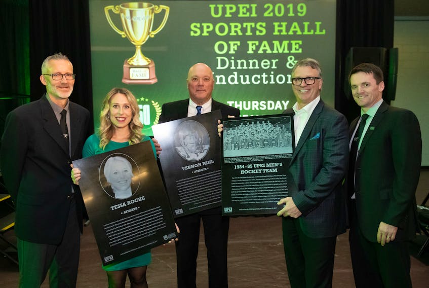 The University of Prince Edward Island welcomed three legends into the UPEI Sports Hall of Fame on Thursday night as part of its sports legacy celebration. Tessa Roche, from second left, Vernon Pahl, and Doug Currie, representing the 1984–85 UPEI men’s hockey team (of which he captained) will be the 48, 49 and 50th inductees, respectively, bringing the total membership of the UPEI Sports Hall of Fame to 50. Also pictured are Ron Annear, left, varsity sport co-ordinator at UPEI, and Chris Huggan, right, athletic director at UPEI. The UPEI Sports Hall of Fame was founded in 2001 to recognize individuals who have made significant contributions to the athletic programs at UPEI, Saint Dunstan’s University or Prince of Wales College. Each year, individual athletes, teams, and builders are inducted to honour their contributions towards the university’s athletic success or community leadership. Stories on the inductees will be published in an upcoming edition of The Guardian and the Journal Pioneer. Submitted
