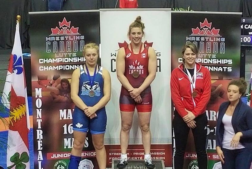 Veronica Keefe, centre, recently won the 72-kilogram division at the Canadian senior wrestling championship.