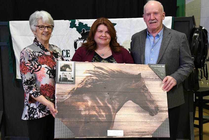 Dr. Kathleen MacMillan, centre, presents the AVC equine ambulator award for horse of the year to Caryl and Reg MacPherson for Sock It Away. MacPherson has won the award three times in recent years.