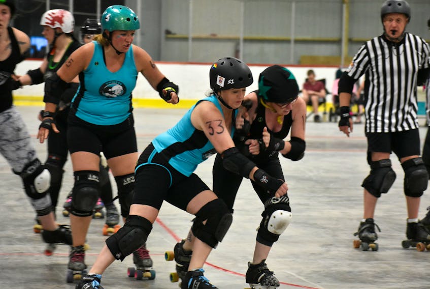 Twisted Sister Sally Bernard, also known as “Vandana Shove’r,” from left, rolls to assist teammate Holly Osborne, “Sugar and Slice,” block Tar City’s Lindsay McKinnon, “Turbolinds'' during the Lobster Clawber at The Plex in Slemon Park recently.