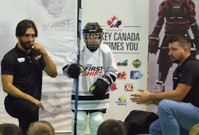 First Shift program fitter Julian Fierro, left, demonstrates where Drew Pitre, centre, should have his stick cut to the proper length while fitter Dylan Couture, far right, looks on. The professional hockey gear fitters were at the recent First Shift welcome event in Stratford.