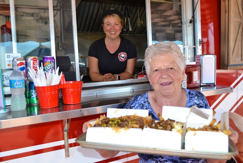 Up West Fire Fries owner Kelly Wilson looks on as Noreen Gaudet from Harper Road heads off with her tray of fresh-cut, fresh-cooked fries.