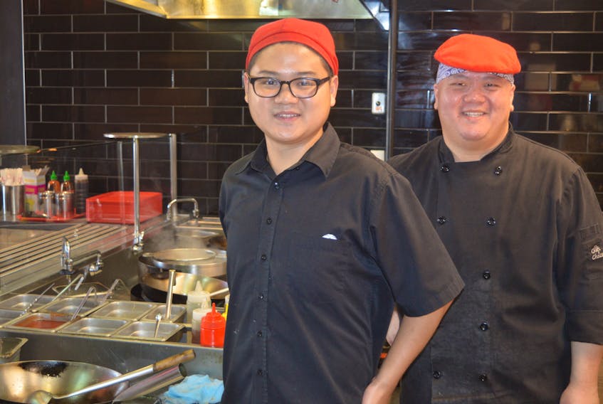 Andy Li, left, and Edward Chan at Mad Wok on Queen Street in Charlottetown pose for a photo during a busy lunch time earlier this week. The restraurant’s owners said two years ago when they opened the plan was to expand to more locations on P.E.I. They plan on opening a second location in Charlottetown in November at Belvedere Plaza.