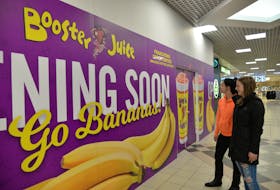 Hailee Young, left, and Ashley Gallant check out the sign in the Charlottetown Mall on Thursday announcing that Booster Juice is a new tenant. The space was previously occupied by Juice Co.