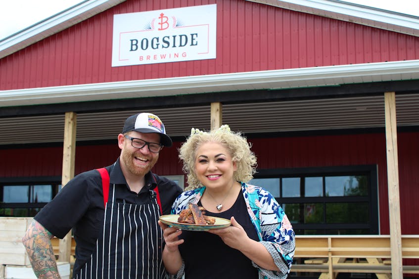 Chef Ilona Daniel helps Bogside Brewing’s chef Dave Mottershall show off his grilled ribs with a peach-bourbon barbecue sauce outside the brewery’s Montague location. - Stephen Brun