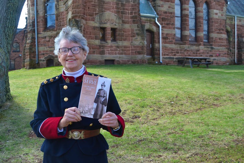 Katherine Dewar holds a copy of her new book, “Called to Serve: Georgina Pope – Canadian Military Nursing Heroine”, which will be launched in Charlottetown on May 24 and in Summerside on June 24. She is standing on the site of St. Paul’s Anglican Church, which was attended by Pope in the 1800s. That church was replaced by the present stone structure in 1896. Pope’s grandfather, Theophilus Desbrisay, was the first Anglican cleric on St. John’s Island.