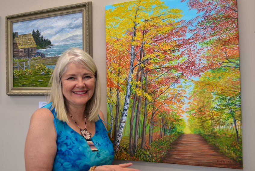 Artist Ann Clow shows her painting, “An Autumn Walk”. It’s one of the pieces currently on display at Sealand Studio of Contemporary Art in Charlottetown where she is assistant manager.