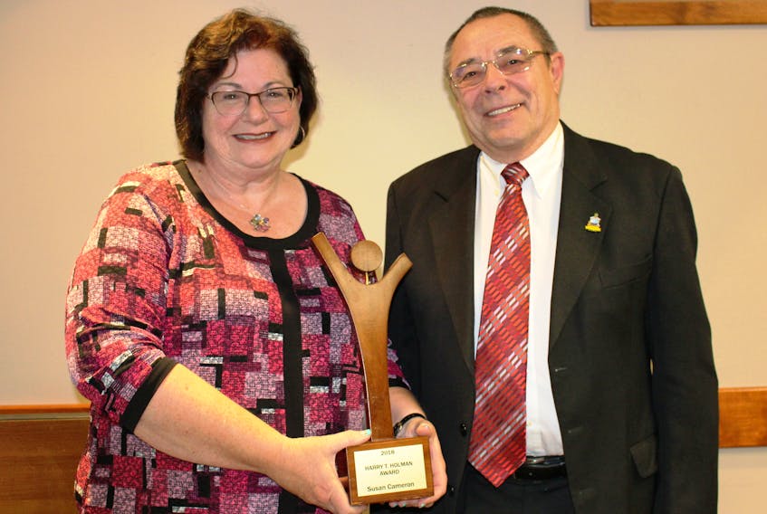 Susan Cameron, left, accepts the Harry T. Holman award from Peter Holman, right, for 26 years of volunteer service with the Prince County Hospital Auxiliary.