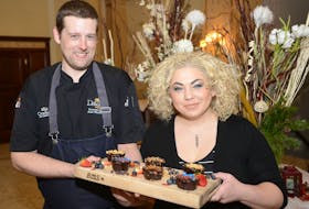 Chef Jesse MacDonald, left, and Chef Ilona Daniel hold up the finished gluten-free chocolate cakes, which contain no flour but plenty of flavour. MacDonald said he enjoys cooking with chocolate because of the depth of flavour and possible pairing combinations, with cardamom, rose and bacon being some of his favourites.