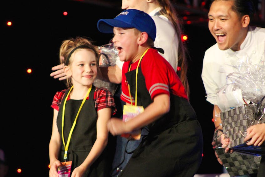 Emery Wood jumps with excitement the moment his name is announced as the winner of the first Junior Chef Challenge at last year’s P.E.I. International Shellfish Festival. Looking on with excitement behind him is his sous-chef Mark Singson, who was the runner-up in season six of Top Chef Canada. On the left is fellow competitor Annabella Sly.