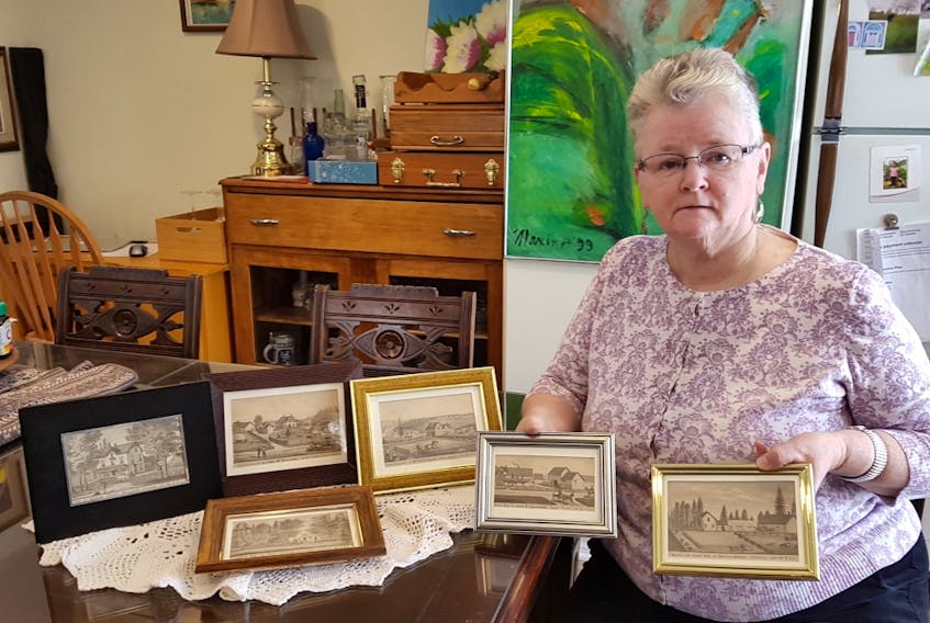 Mary Ellen Callaghan, BIS first vice-president and craft fair vendor, displays some framed one-of-a-kind 1880 Meacham Atlas pictures. All sale proceeds from these items go to support a Christmas family.
