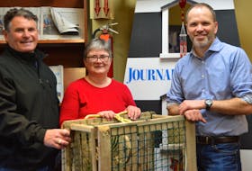 Lobster fisherman Ronnie Bigelow, left, Marlene Campbell of Culture Summerside, and Brad Works, managing editor at the Journal Pioneer, check out one of the traps being used for the Journal Pioneer Lobster Trap Stacking competition at the 62nd annual Summerside Lobster Carnival in Summerside July 12.