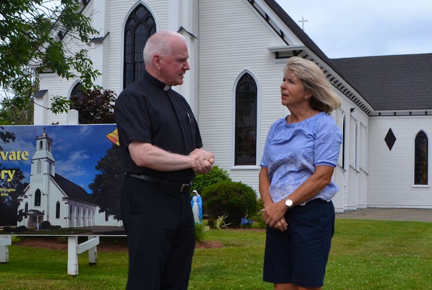 Father Danny Wilson, pastor of St. Anthony’s Parish in Woodstock, and Susan Shea, chairwoman of the parish’s property and finance committee, discuss plans for the annual parish picnic Sunday, Aug. 5.