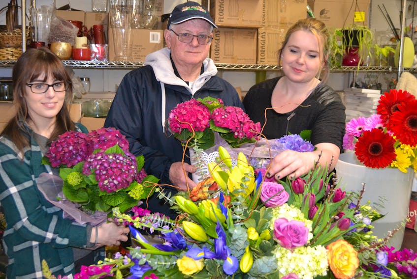 Staff members Mary Langille, left, and Mary-Kate Stuart load George Maker up with flowers to be delivered at Hearts and Flowers in Charlottetown.