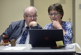 Montague Mayor Richard Collins and clerk of the council Jill Walsh look over the IRAC recommendation for Three Rivers amalgamation on Monday night.