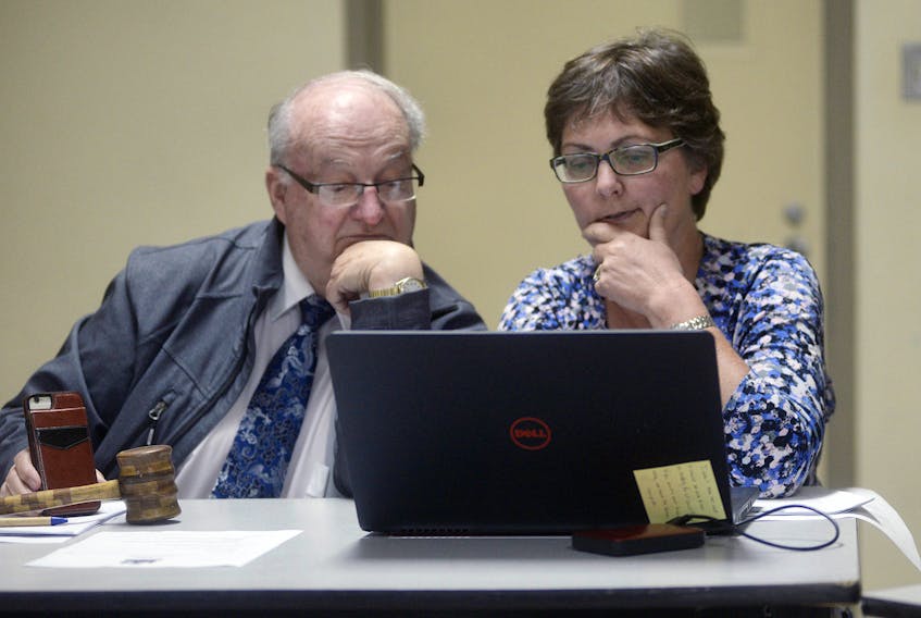 Montague Mayor Richard Collins and clerk of the council Jill Walsh look over the IRAC recommendation for Three Rivers amalgamation on Monday night.
