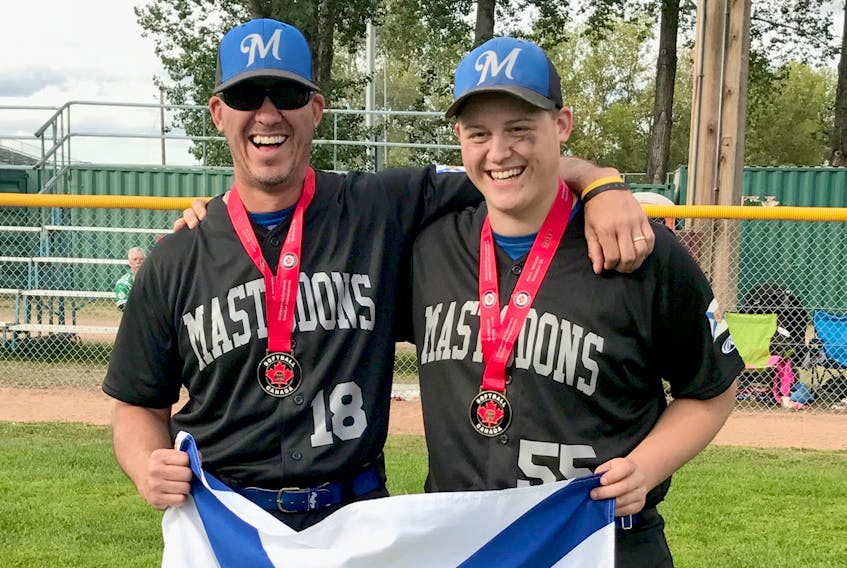 Coach Chris Hopewell, left and son Jake Hopewell celebrate in Saskatoon after winning the Canadian fastpitch championship.