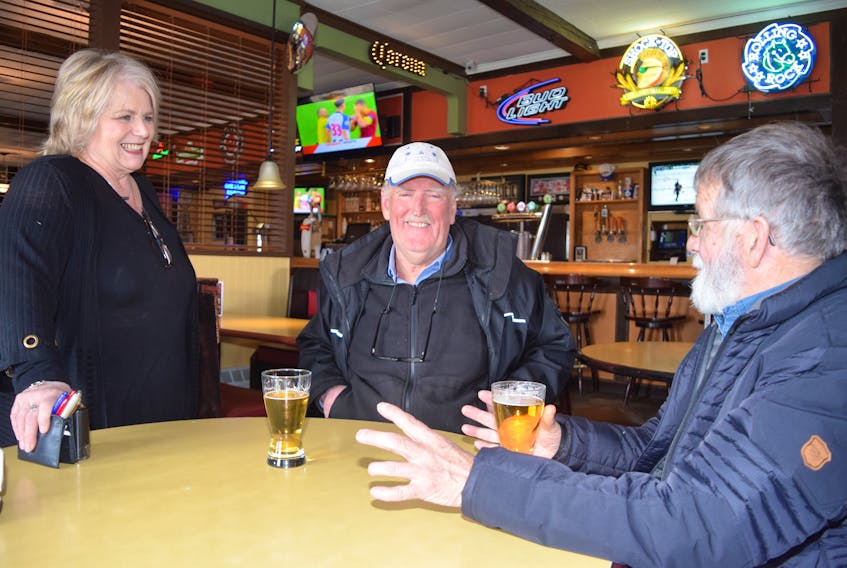 Heather Stewart, who has happily served customers at the Pond Classic Grill for the past five years, is seen chatting with Danny MacDonald, centre, a former waiter when it was called the Ponderosa and long-time customer Kim McCallum, who stopped by for a last cold glass of draft beer and to wax nostalgic over fond memories at the Bible Hill tavern.