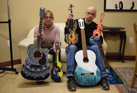 Lori Holman from the Marigold Cultural Centre and David Mingo of Mingo Music Sales show off some of the brightly-painted instruments ready for distribution to local stores. Instruments that include guitars and ukuleles were painted by 15 local artists. Proceeds from the sale of these instruments will be donated to local charities and organizations under the banner of Artists in Harmony.