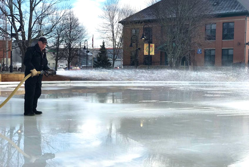 The outdoor skating rink on Civic Square is slowly taking shape and should be ready for use by the end of next week. This municipal worker used a hose connected to a fire hydrant on Prince Street to spray fresh water on the ice on Dec. 7.