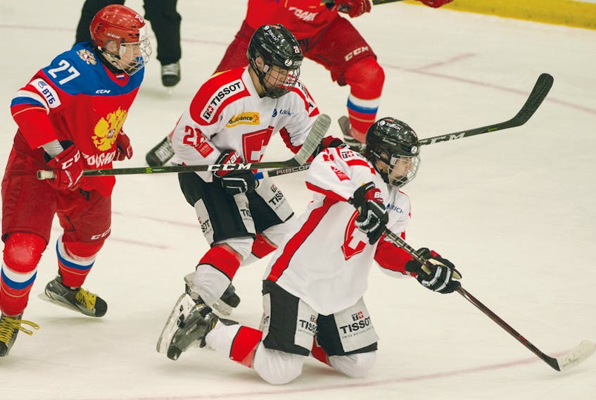 Switzerland's Simon Wuest (2) tries to keep control of the puck from his knees as Russia’s  Maxim Sorkin (27) comes for the puck during their World Junior A Challenge game at the RECC in Truro. Mark Goudge/Truro Daily News
