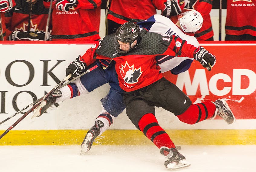Canada West's Brendan Budy stuffs USA’s Tyler Maden into the boards in front of the Canada West bench during World Junior A Challenge action on Tuesday in Truro.