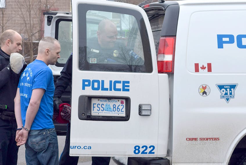Christopher MacKenzie, 38, is seen being loaded into a Truro Police Service van shortly after being arrested on a Canada-wide warrant Tuesday afternoon. He was discovered hiding under a pile of clothes inside a Queen Street apartment.