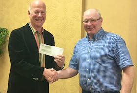 Nova Scotia Federation of Agriculture president Victor Oulton, right, presents Feed Nova Scotia executive director Nick Jennery with a donation of $1,500.